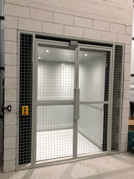 Elevador com enclausuramento em grade metálica instalado em prédio