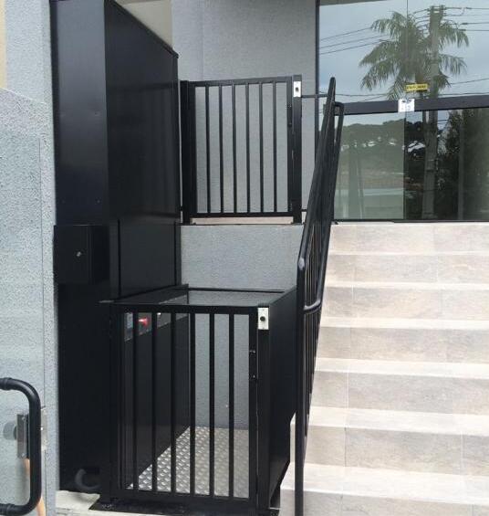 Plataforma de acessibilidade instalada junto à escada de entrada de um edifício